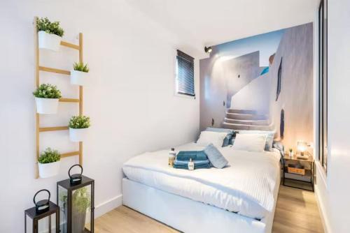 a bedroom with a white bed with plants on the wall at Night Express - Parking Gratuit Lyon Sud in Saint-Genis-Laval