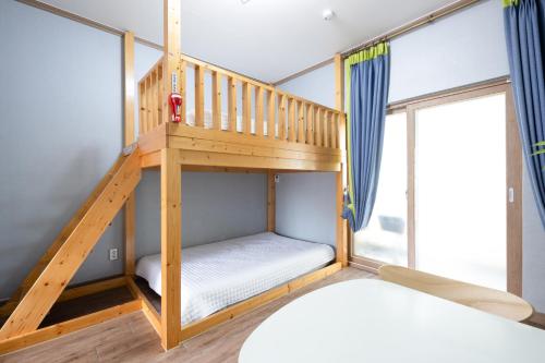 a bunk bed in a room with a ladder at Suncheon Bay Ecology Pension in Suncheon