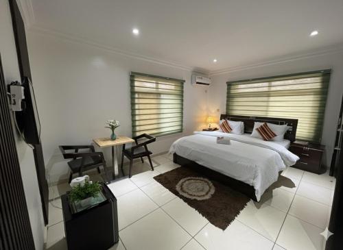 a bedroom with a bed and a table and chairs at TRENDY INN LTD in Lagos