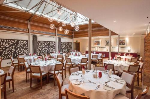 a dining room with white tables and chairs at Rewley House University of Oxford in Oxford