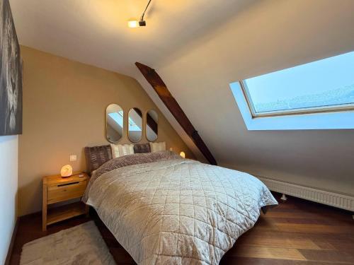 a bedroom with a bed with four mirrors on the wall at Cosy Duplex pour 4 personnes à Soignies in Soignies