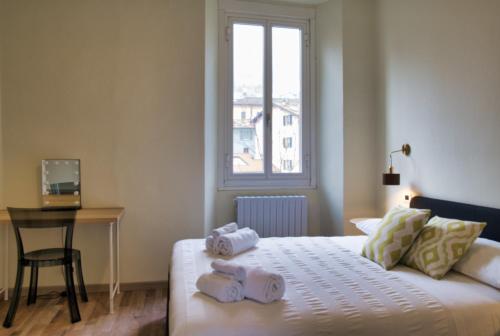 a bedroom with a bed with three towels on it at Cozy home away in Lecco