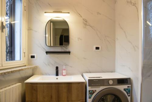 a bathroom with a washing machine and a sink at Cozy home away in Lecco
