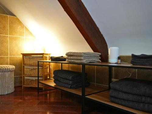 a pile of towels sitting on a shelf in a room at Cosy Duplex pour 4 personnes à Soignies in Soignies