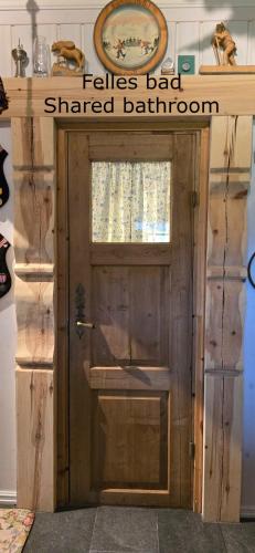 a door with a sign that reads fischer bad shared bathroom at Smia cabin , A Unique Rustic Hideaway in Lii