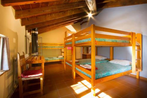 a room with three bunk beds in a house at Riera d'Agres, relax, rural, grupos in Agres
