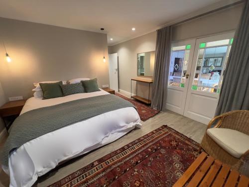 a bedroom with a large bed and a chair at Misty Moon in Malgas