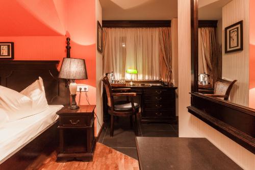 a bedroom with a bed and a desk with a chair at Hotel Aviv Dresden in Dresden