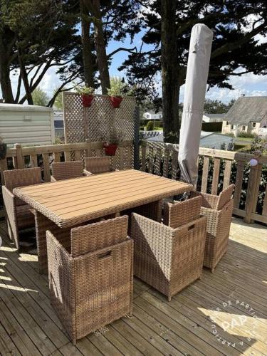 a wooden table and baskets on a wooden deck at Chalet du Mont-Saint-Michel in Saint-Jean-le-Thomas