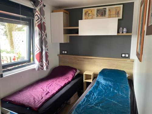 a small room with a bed and a window at Chalet du Mont-Saint-Michel in Saint-Jean-le-Thomas