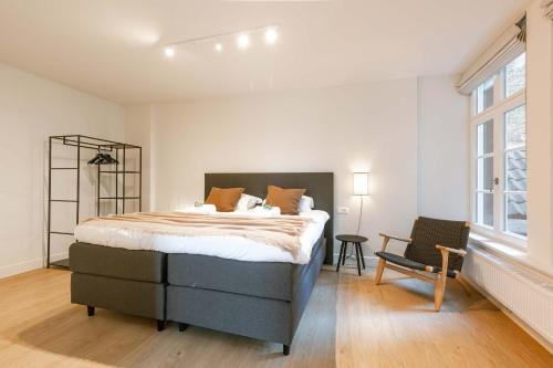a bedroom with a bed and a chair and a window at Apartment near Antwerp Cathedral in Antwerp