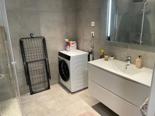 a bathroom with a washing machine and a sink at Hotell Sjyen in Nesna