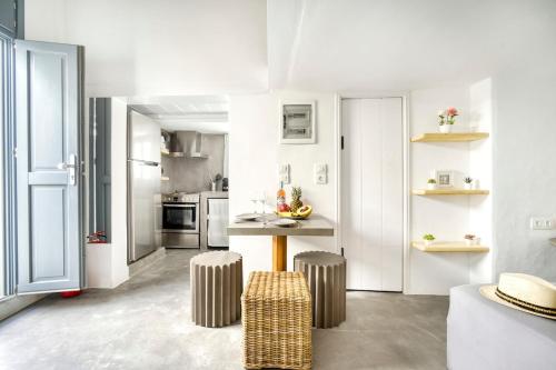 a kitchen with a table and two stools at Mykonos Yialos Town Home Loft - by Hospirit in Mikonos