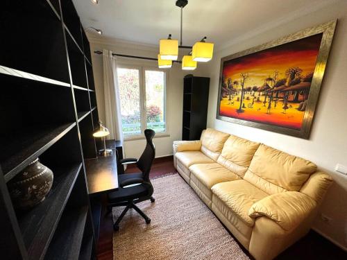 a living room with a couch and a painting on the wall at Formosa Beach Apartment Vista Mar a 2 Minutos da Praia in Funchal