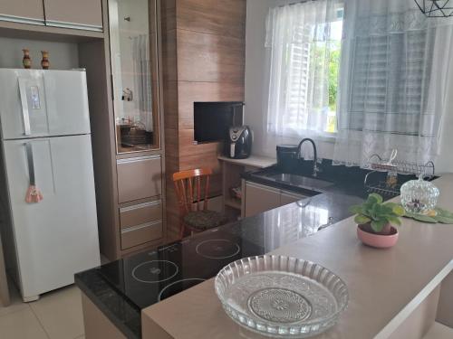 a kitchen with a white refrigerator and a counter top at Casa Lovato in Arroio do Sal