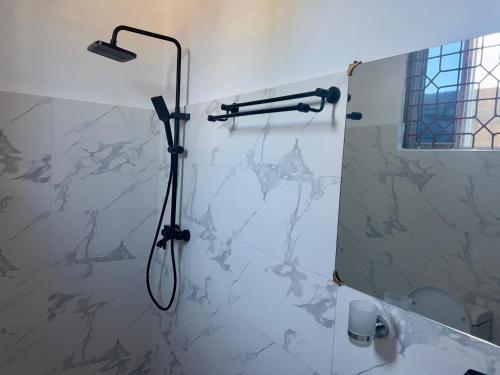 a shower in a bathroom with a marble wall at Kendwa Crystal Coast Hotel in Kendwa