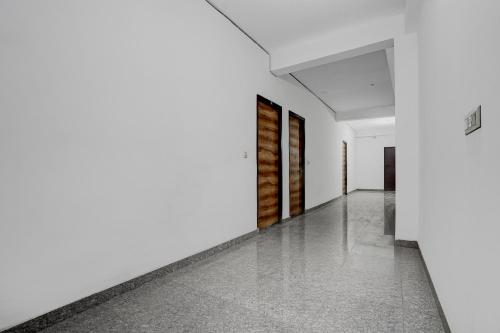 an empty hallway with white walls and wooden doors at SPOT ON VS in Delhi