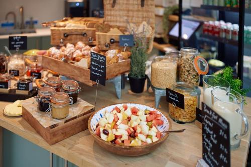 a table with a bowl of apples and jars of food at Rhodes House, Oxford in Oxford