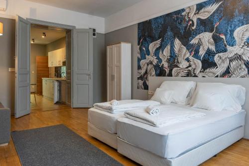 a bedroom with a white bed with a painting on the wall at Csaba Vendégház in Izsák