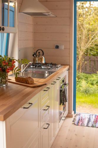 a kitchen with a sink and a stove at Lawendowe Pole - Domek Różany in Nowe Kawkowo
