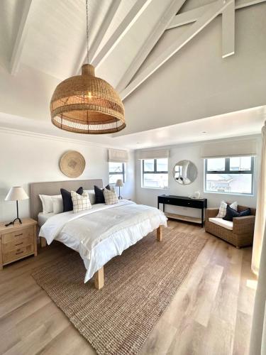 a bedroom with a large bed and a chandelier at White Wicker House in Langebaan