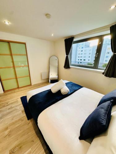 a bedroom with a large bed and a window at Waters View in Edinburgh