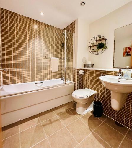 a bathroom with a tub and a toilet and a sink at Waters View in Edinburgh