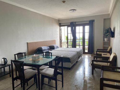 a bedroom with a bed and a table and chairs at Lippo Carita Selatan in Carita