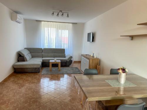 a living room with a couch and a table at Hársfa Central Apartment in Mórahalom
