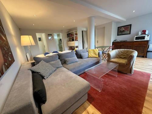 a living room with a couch and a table at Chambre-Studio et SAUNA indépendants in Annecy