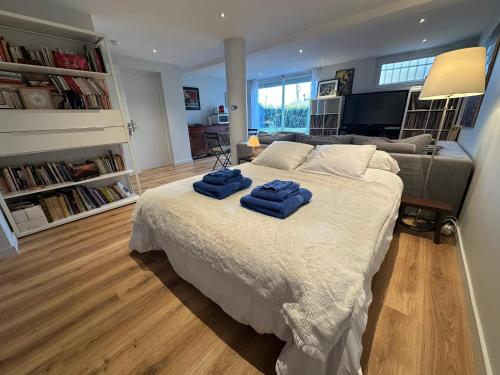 a bedroom with a bed with two blue towels on it at Chambre-Studio et SAUNA indépendants in Annecy