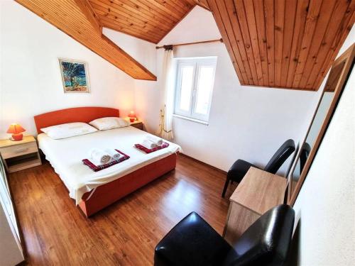 a bedroom with a bed and a table and chairs at Apartmani Banić Apartman 5 in Postira