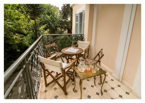 a balcony with two chairs and a table with glasses on it at Archontiko Stamou in Zagora