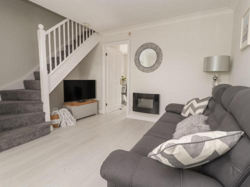 a living room with a couch and a staircase at Castle View in Deganwy