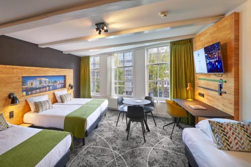 a hotel room with two beds and a desk at Nova Hotel in Amsterdam