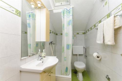 a bathroom with a sink and a toilet and a mirror at Apartmani Banić Apartman 5 in Postira
