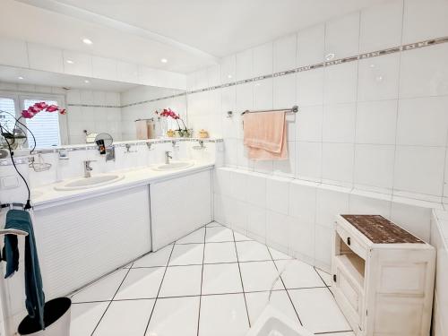 a white bathroom with two sinks and two mirrors at Maison 4 ch, véranda, proche commodités, Aurillac in Aurillac