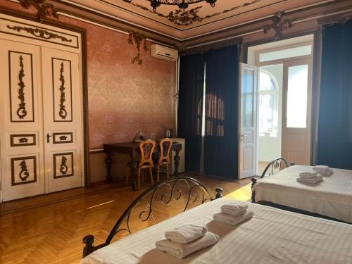 a room with two beds and a table and chairs at Приватна садиба Фортеця Малехів in Lviv