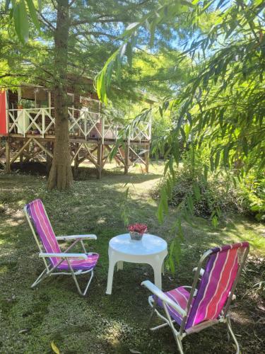 two chairs and a table with a table and a tree at Cabaña bruji in Tigre