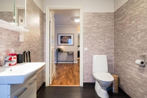 a bathroom with a white sink and a toilet at Guestly Homes - Spacious Top Floor 2BR Residence in Luleå