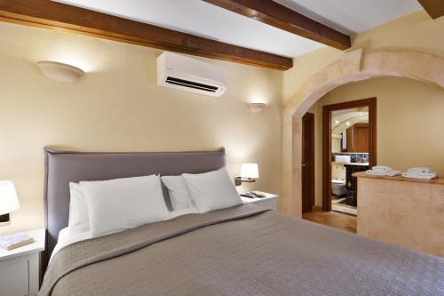 a bedroom with a large bed with white pillows at Villa Sophia in Port d'Andratx