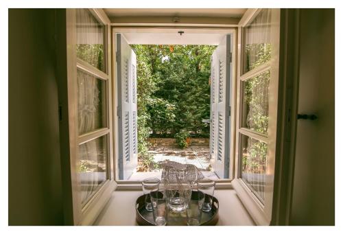 an open window with a table with wine glasses on it at Archontiko Stamou in Zagora