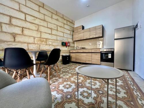 a kitchen with two tables and a refrigerator at Turretta Stay - Private Room with Ensuite Bathroom in Vittoriosa, Three Cities in Birgu