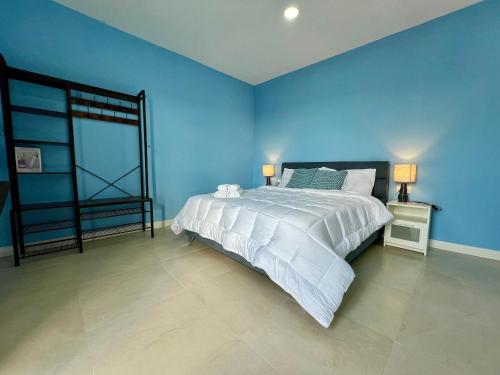a blue bedroom with a bed and a blue wall at Turretta Stay - Private Room with Ensuite Bathroom in Vittoriosa, Three Cities in Birgu