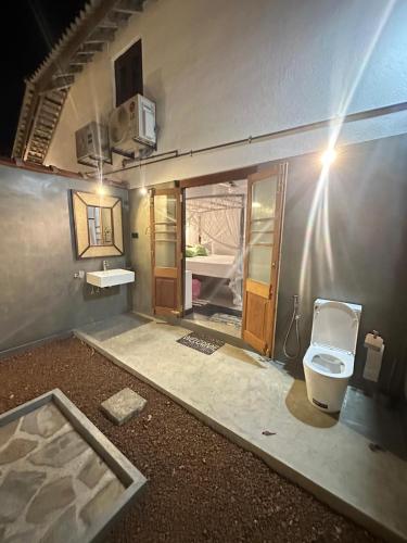 a bathroom with a toilet in a room at Woradi Solitude Bungalow in Talpe