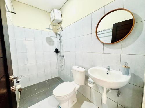 a bathroom with a toilet and a sink and a mirror at Umah Anami in Jimbaran