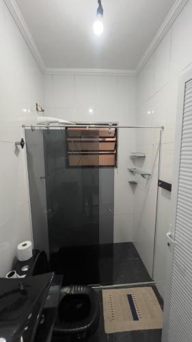 a bathroom with a glass shower with a toilet at JK Casa de Praia in Ilha Comprida