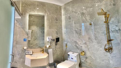 a bathroom with a toilet and a sink and a shower at Golden Dream Hotel in Khamis Mushayt