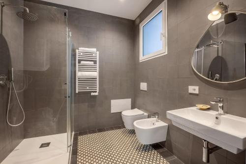 a bathroom with a toilet and a sink and a shower at Top-Floor Sea View with Pool Access in Catania