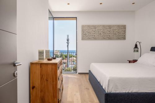 a bedroom with a bed and a large window at Top-Floor Sea View with Pool Access in Catania